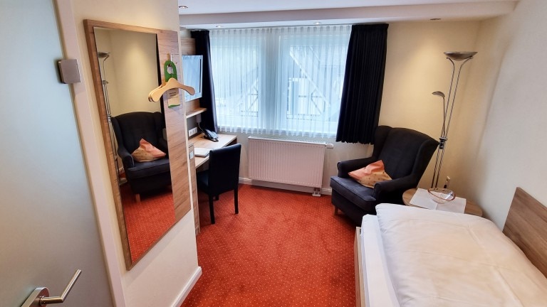 Zimmer mit einem Schreibtisch und Sitzgelegenheit.