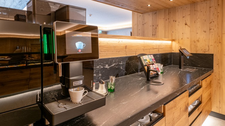 Koffiecorner met koffiezetapparaat, theefaciliteiten en sapmachine.