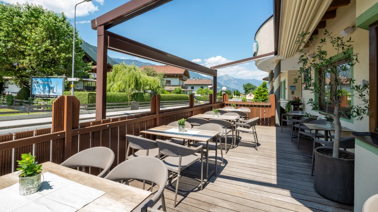 Terras met houten vlonder aan de weg met uitzicht op de bergen.
