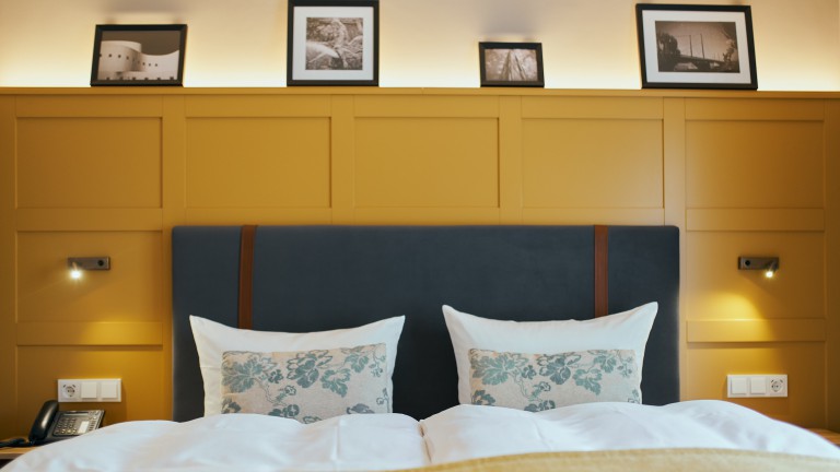 Tweepersoonsbed met de telefoon links.