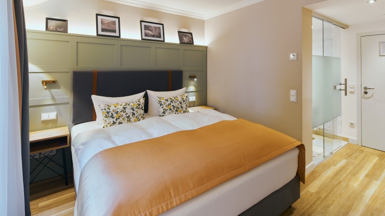 Standaard kamer orange met kingsizebed en rechts de badkamer.