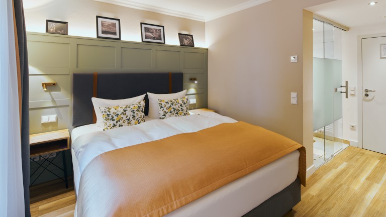 Standaard kamer orange met kingsize bed en badkamer rechts.