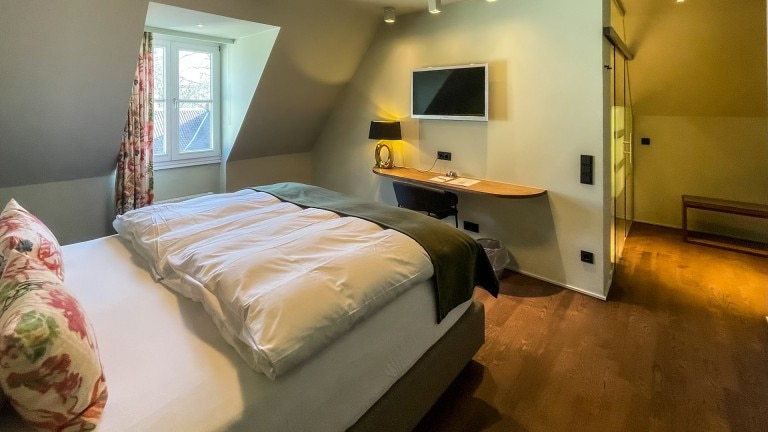 Standaard kamer Pomelo met tweepersoosnbed, televisie en bureau.