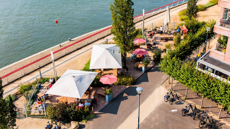 Terras van Stadshotel Doesburg met parasols aan het water.