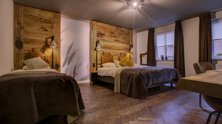 Geräumiges Hotelzimmer mit zwei Betten, einem Zusatzbett und einem Büro.