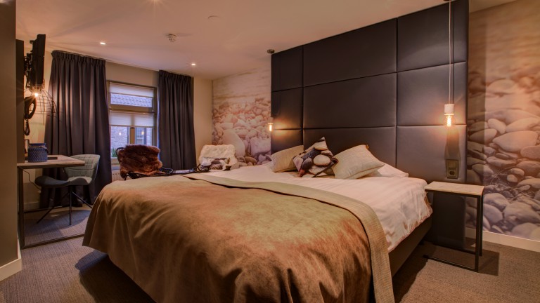 Hotelzimmer mit Wärmesphären, einem Doppelbett, einer Rückbank und einem Sitz.